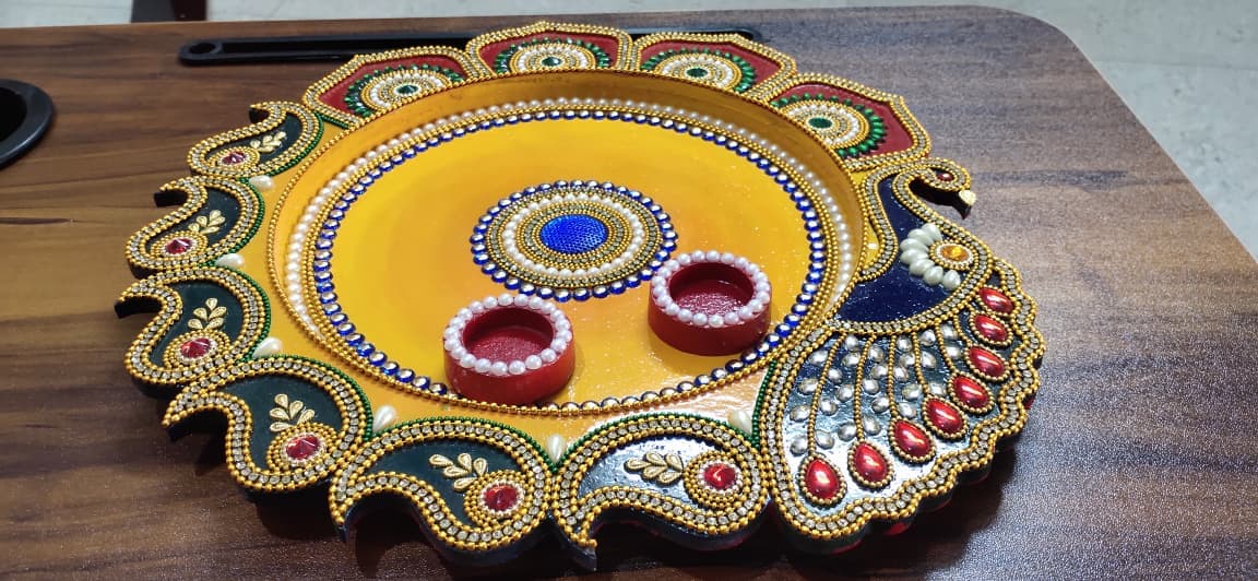 Yellow and green peacock-shaped aarti thali with diya holders and elaborate kundan work