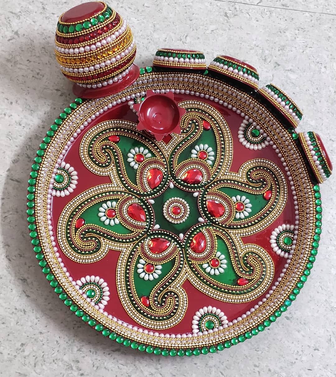 Green and red handcrafted pooja thali with paisley kundan patterns, pearl border and kalash